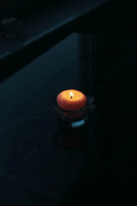 a lit candle sitting on top of a table, floating
