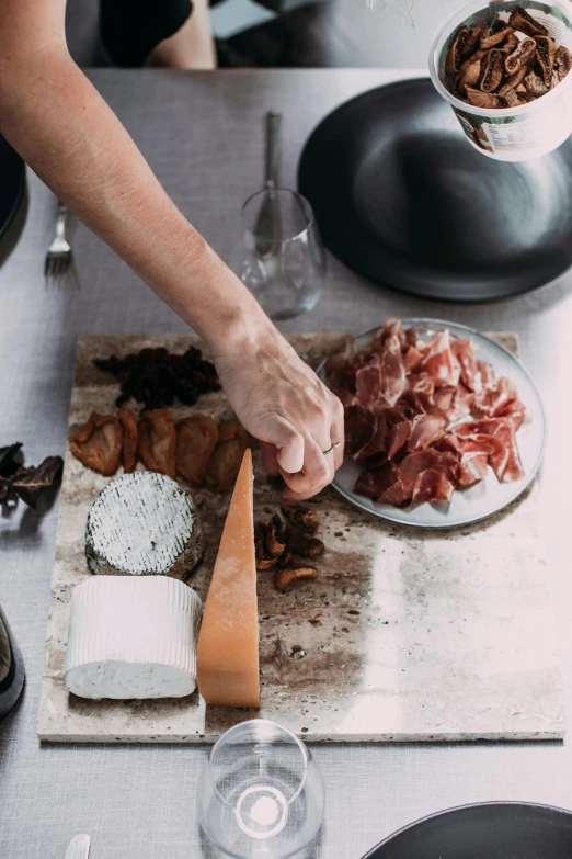 a close up of a person cutting food on a cutting board, inspired by Jacopo Bellini, rituals, slate, australian, wine