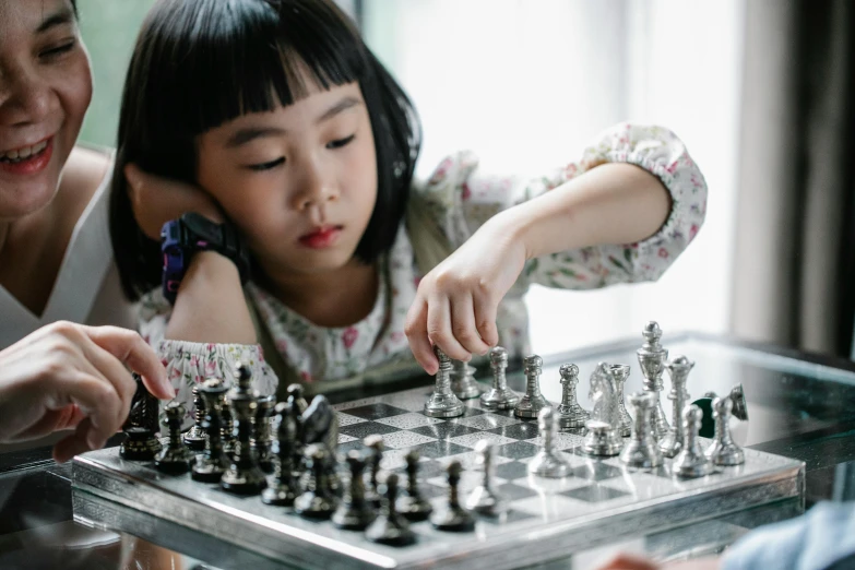 a woman and a child playing a game of chess, inspired by Zhou Wenjing, pexels contest winner, interactive art, girl silver ponytail hair, thumbnail, lalisa manobal, schools