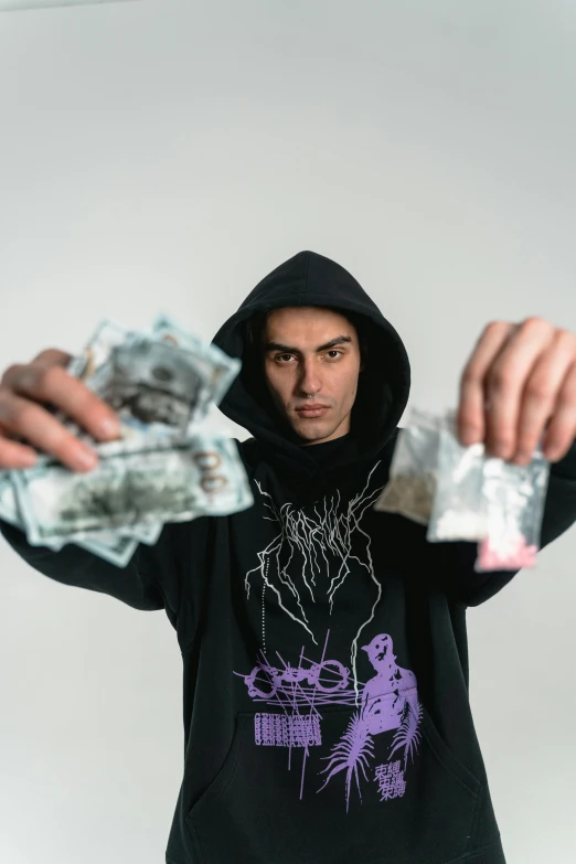 a man in a black hoodie holding a bunch of money, an album cover, pexels contest winner, antipodeans, purple drank, headshot profile picture, hasan piker, witchcore