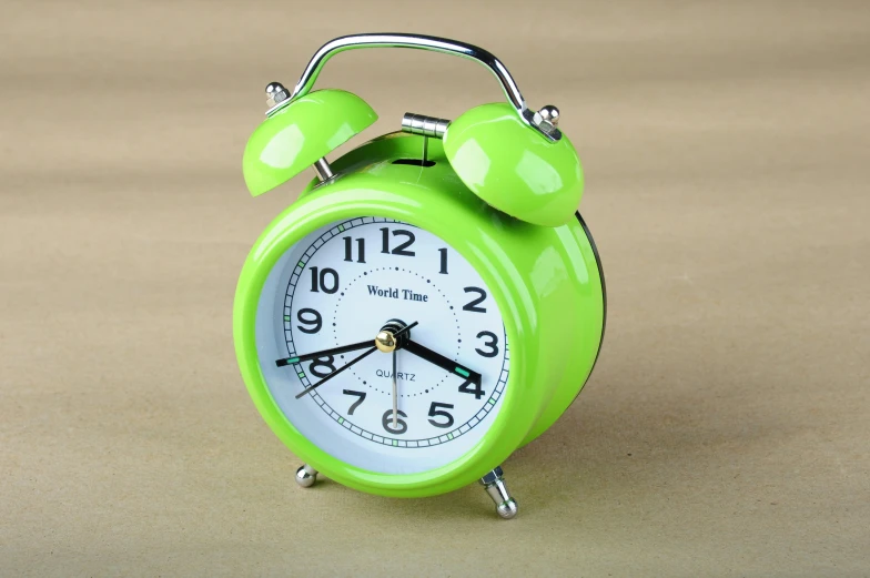 a green alarm clock sitting on top of a table