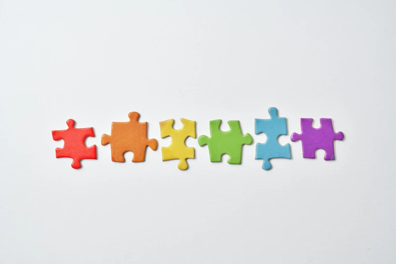 colorful puzzle pieces arranged in a row on a white surface, trending on pexels, stitched together, background image, dezeen, toys