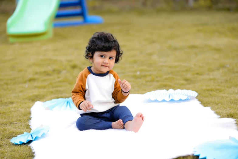 a small child sitting on a blanket in the grass, an album cover, inspired by Myles Birket Foster, pexels contest winner, blue slide park, full body image, vinayak, ready to eat