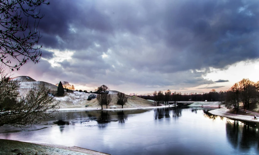 a body of water sitting under a cloudy sky, in the winter, esher, riverdale, parks and lakes