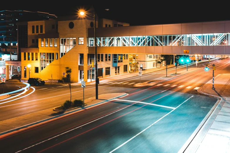 a city street filled with lots of traffic at night, a picture, by Lee Loughridge, unsplash contest winner, visual art, bus station, empty streetscapes, ayne haag, yellow artificial lighting