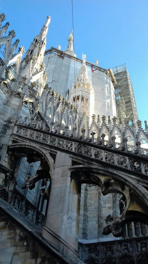 a very tall building with a very steeple, inspired by Taddeo Gaddi, archways between stalagtites, intricate carving, grey, neogothic