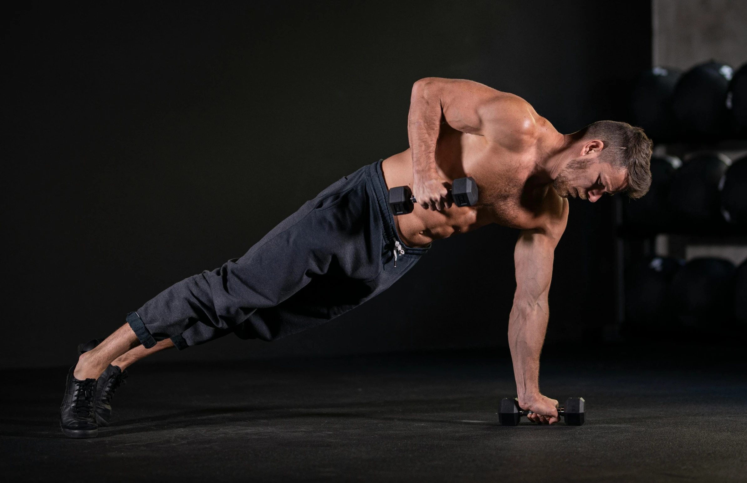 a man doing push ups in a gym, by Adam Marczyński, pexels contest winner, figuration libre, side pose, performing on stage, studio photo, handling riffle on chest