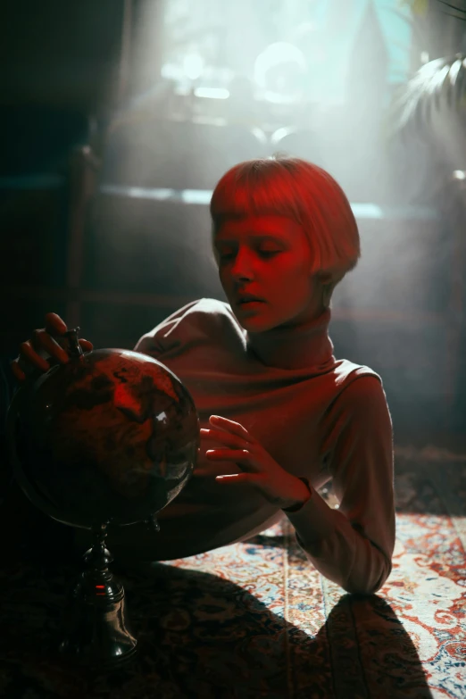 a woman sitting on a rug holding a globe, a hologram, inspired by E. T. A. Hoffmann, pexels contest winner, magic realism, movie still from bladerunner, girl with short white hair, russian cinema, andrei tarkovsky scene