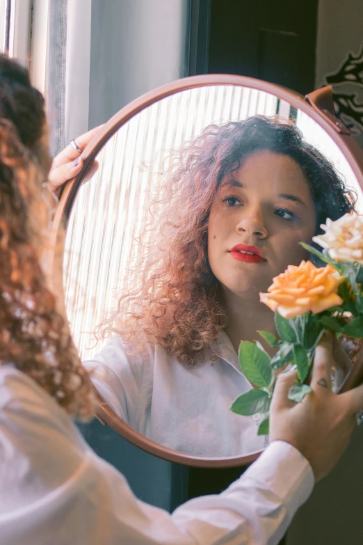 a woman holding a bouquet of flowers in front of a mirror, inspired by Elsa Bleda, pexels contest winner, renaissance, brown curly hair, tessa thompson inspired, growing out of a giant rose, teenage girl