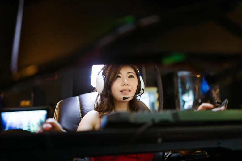 a woman sitting in a car wearing a headset, by Jason Felix, led gaming, asian, professional photo, bottom angle