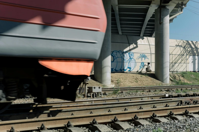 a train passing under a bridge with graffiti on it, a portrait, unsplash, neo rauch and nadav kander, 2000s photo, in tokio, pipelines