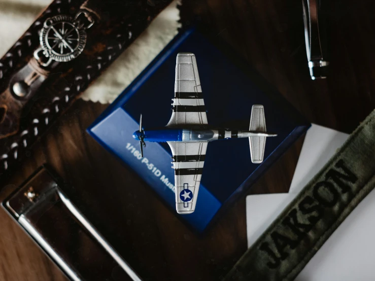 an airplane sitting on top of a wooden table, mustang, flatlay, detailed product image, navy