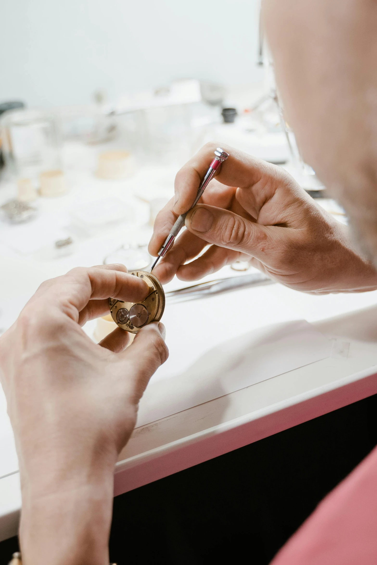 a man sitting at a table with a glass of wine, smoking soldering iron, holding gold watch, zoomed in, creating a soft