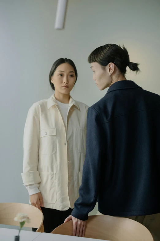 two women standing next to each other in a room, a portrait, by Kim Tschang Yeul, unsplash, minimalism, wearing a linen shirt, wearing jacket, asian man, off - white collection