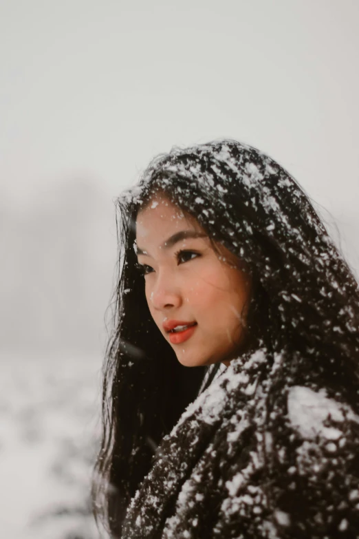 a woman that is standing in the snow, inspired by helen huang, pexels contest winner, halfbody headshot, malaysian, 1 2 9 7, low quality photo