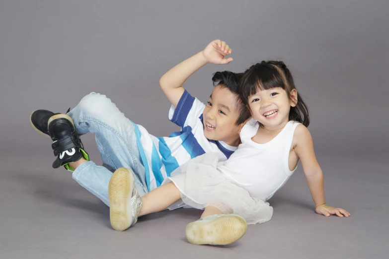 a couple of kids laying on top of each other, by Basuki Abdullah, pixabay, shin hanga, modeling studio, avatar image, sitting on the floor, both smiling for the camera