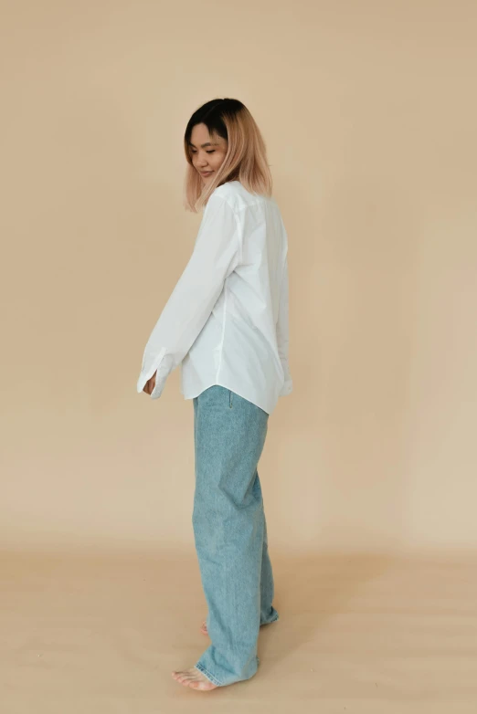 a woman in a white shirt and blue jeans, an album cover, inspired by Ruth Jên, trending on unsplash, full body character portrait, baggy pants, detailed product image, long shirt