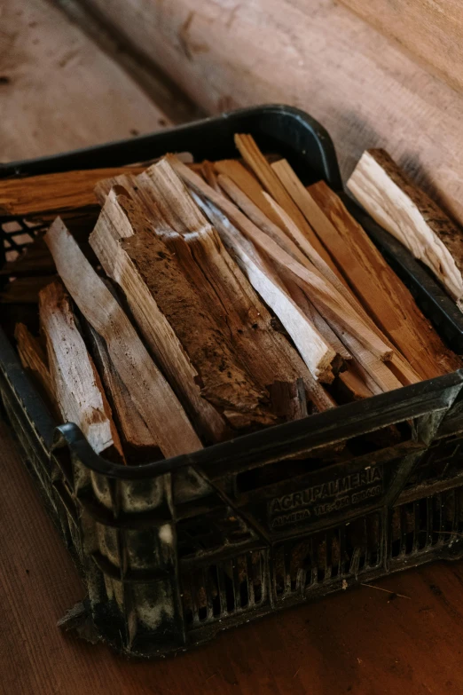 a basket filled with wood sitting on top of a wooden table, cinnamon, woodfired, but is mostly wood, up close