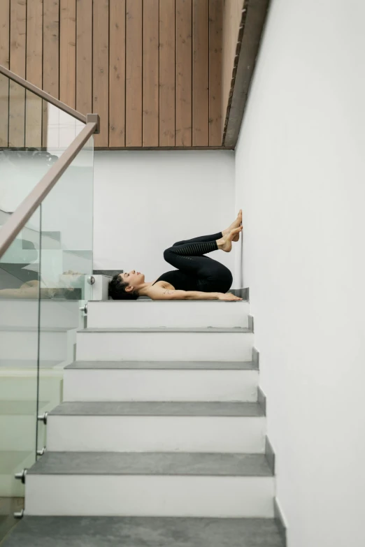 a woman that is laying down on some stairs, by Nina Hamnett, minimalism, yoga pose, dwell, structural, bo chen