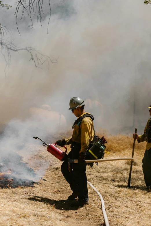 a group of firefighters standing next to a fire, by Arnie Swekel, heat haze, spraying liquid, justin kohn, dwell