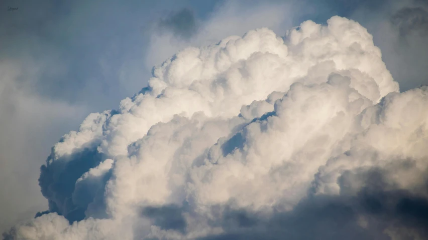 a jetliner flying through a cloudy blue sky, an album cover, unsplash, precisionism, giant cumulonimbus cloud, soft and fluffy, ignant, close - up photograph