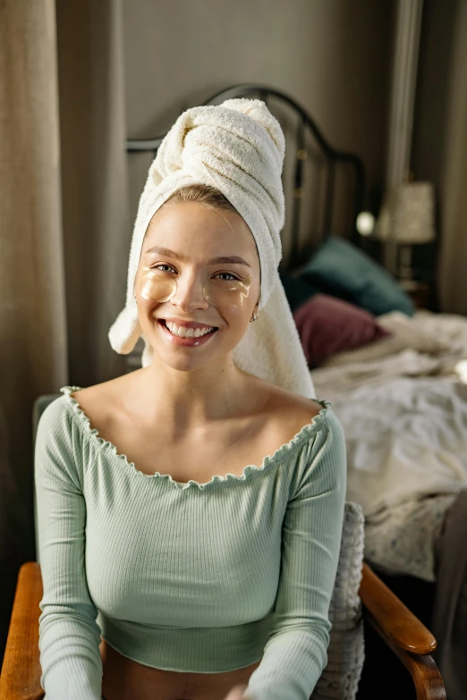 a woman sitting in a chair with a towel on her head, deep dimples, someone in home sits in bed, promo image, perfect facial symettry