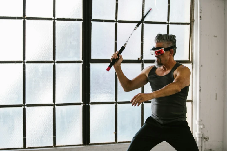 a man holding a tennis racquet in front of a window, inspired by Liao Chi-chun, interactive art, ninja warrior, wearing goggles, practising sword stances, wearing 3 d glasses