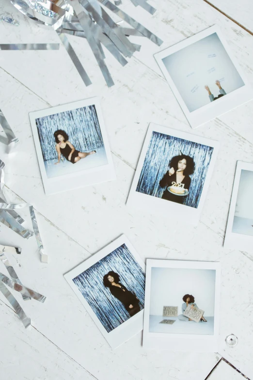 a bunch of polaroids sitting on top of a table, a polaroid photo, inspired by Elsa Bleda, holography, nathalie emmanuel, sassy pose, confetti, portrait of vanessa morgan