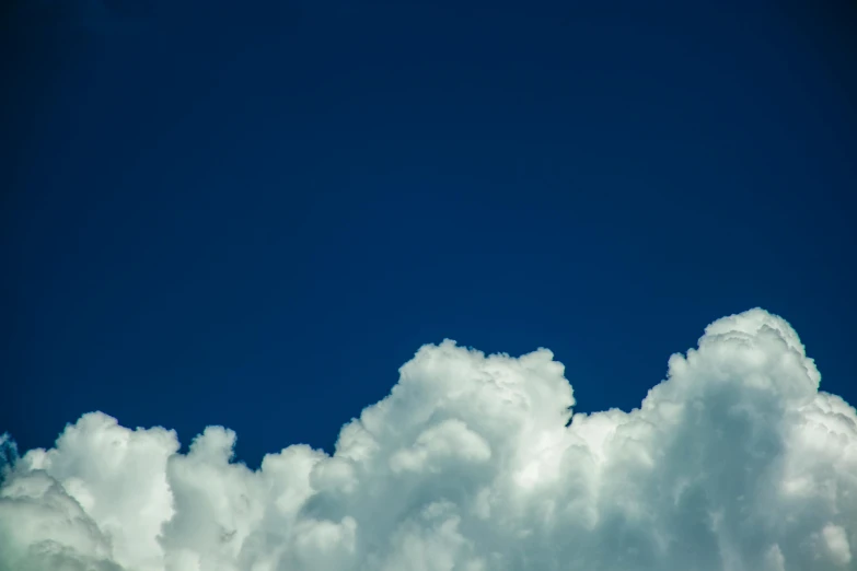 a plane flying through a cloud filled blue sky, by Jan Rustem, unsplash, minimalism, towering cumulonimbus clouds, portrait photo