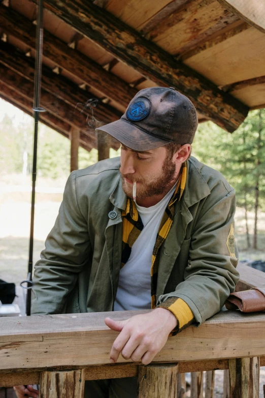 a man standing on top of a wooden deck, a portrait, process art, hat and hoodie, in a cabin, ruggedly handsome ranger, plating