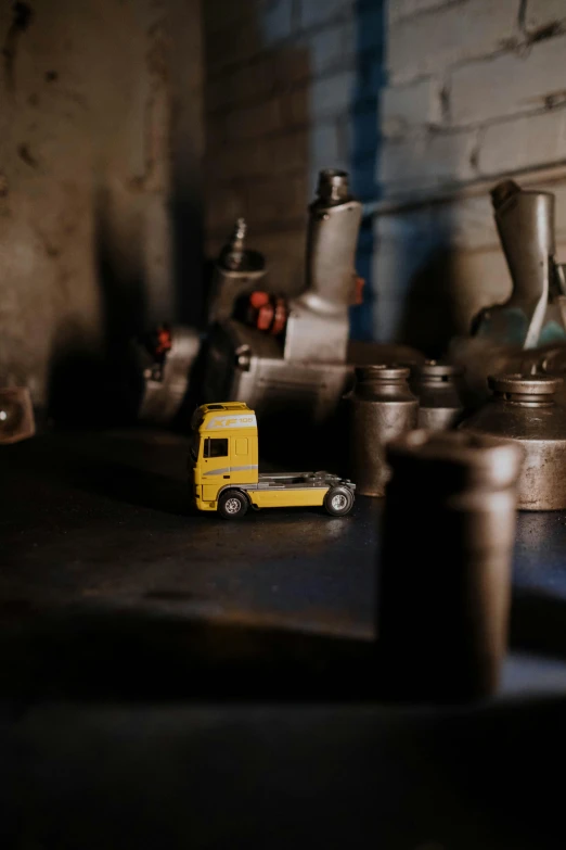 a yellow toy truck sitting on top of a table, by Andries Stock, pexels contest winner, working in the forge, portrait of small, smooth tiny details, forgotten