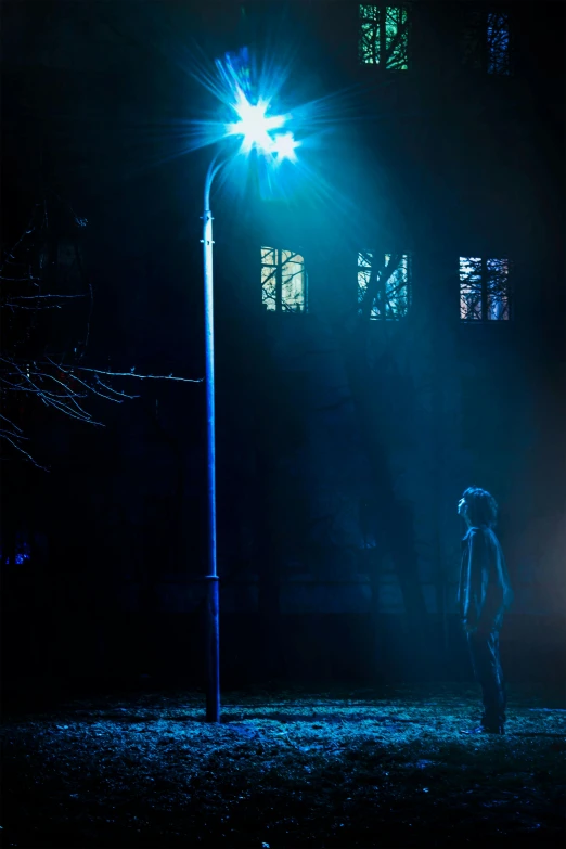 a person standing under a street light in the dark, inspired by Gottfried Helnwein, blue fog, production photo, slender man, light over boy