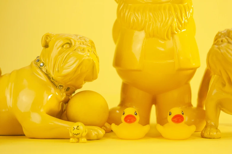 a group of yellow figurines sitting next to each other, an album cover, inspired by Jeff Koons, unsplash, action bronson, the macho duck, anthropomorphic dog cleaning, detailed product image