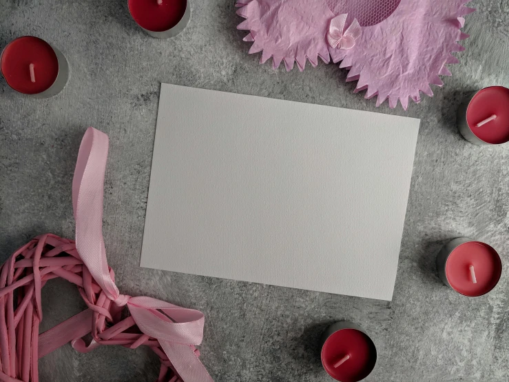 a piece of paper sitting on top of a table next to candles, inspired by Marie Laurencin, pexels contest winner, dressed as a ballerina, magenta and gray, blank paper, lingeries beauty