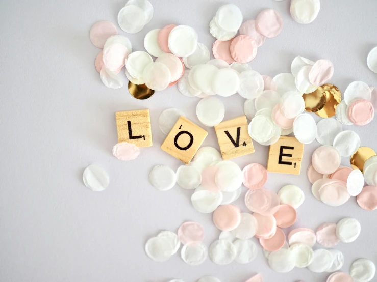 a white table topped with lots of pink and white confetti, pexels contest winner, aestheticism, smokey burnt love letters, background image, love craft, cubes on table