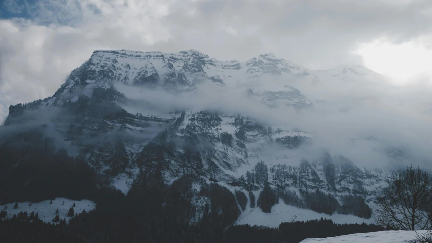 a man riding skis down a snow covered slope, a matte painting, pexels contest winner, gloomy and foggy atmosphere, “ aerial view of a mountain, grey, 4 k hd wallpapear