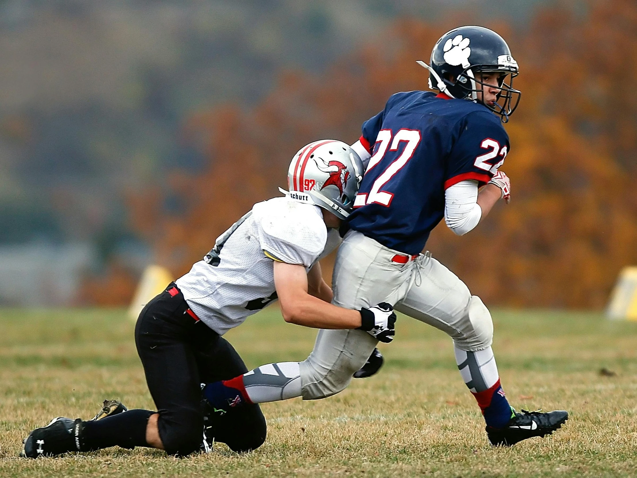 a group of young men playing a game of football, by Paul Davis, shutterstock, fall season, hugging his knees, high-speed sports photography, tom brady