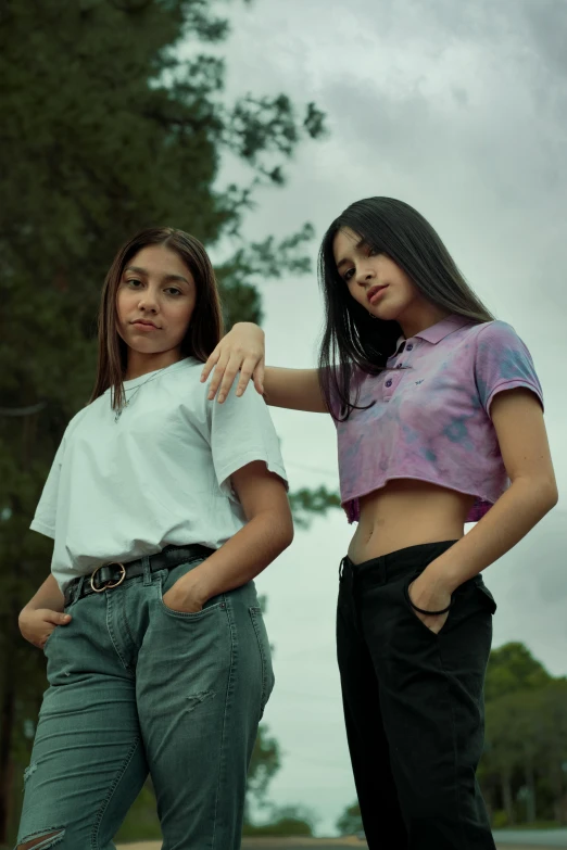 a couple of women standing next to each other, a colorized photo, by reyna rochin, trending on pexels, realism, wearing polo shirt, teenage girl, promotional image, croptop
