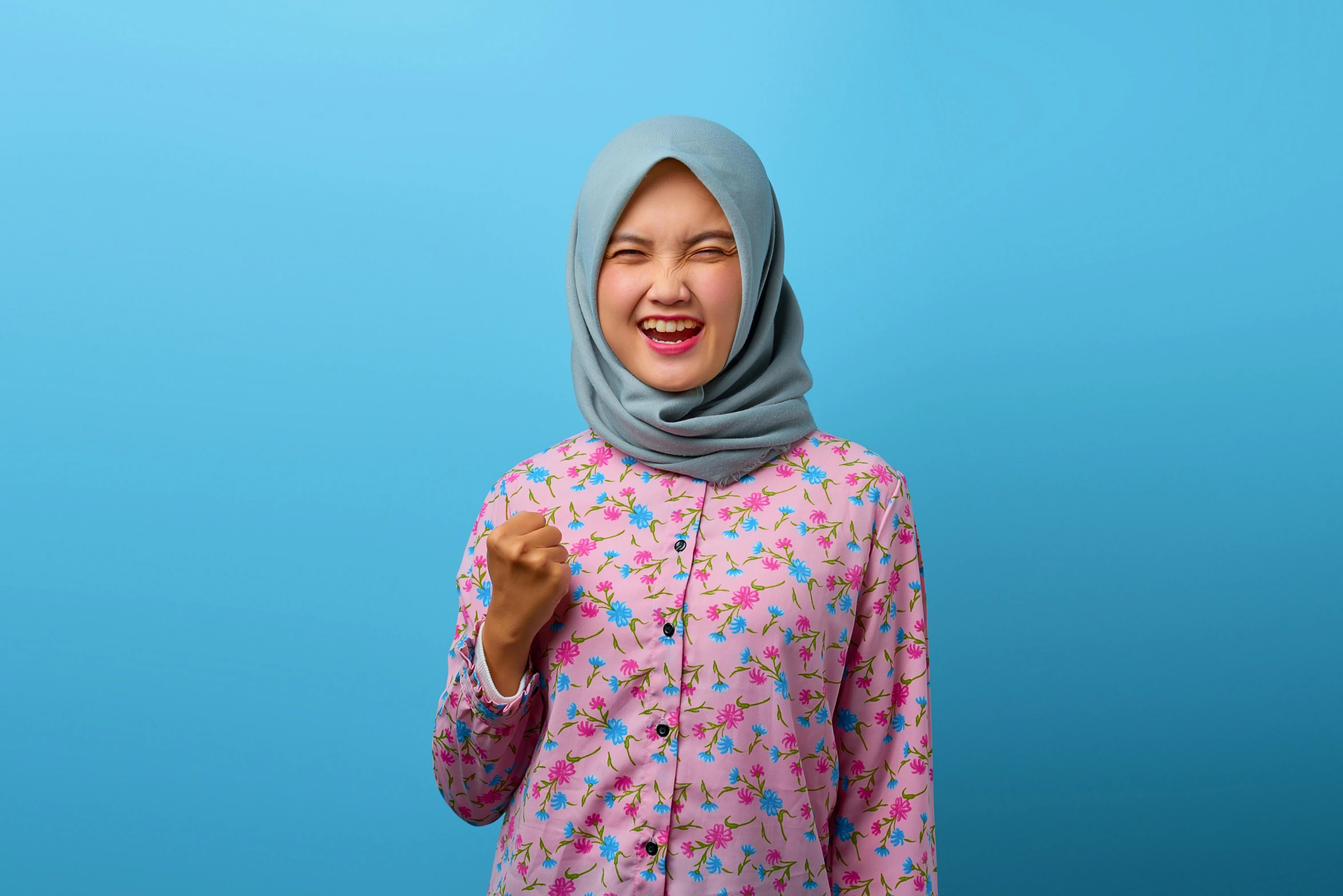 a woman wearing a hijab on a blue background, inspired by Kim Jeong-hui, shutterstock contest winner, hurufiyya, pink shirt, excitement, wearing pajamas, patterned