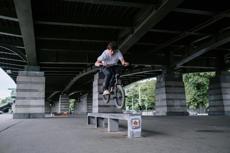 a man flying through the air while riding a bike, unsplash, realism, sitting under bridge, bench, 8k octan photo, sitting on top a table