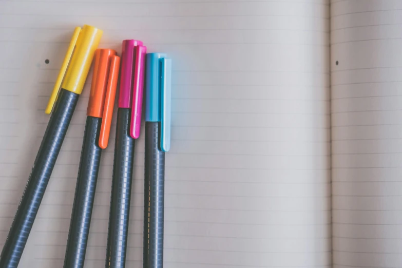 a bunch of pens sitting on top of a notebook, pexels, minimalism, with fluo colored details, multiple stories, colourised, thumbnail