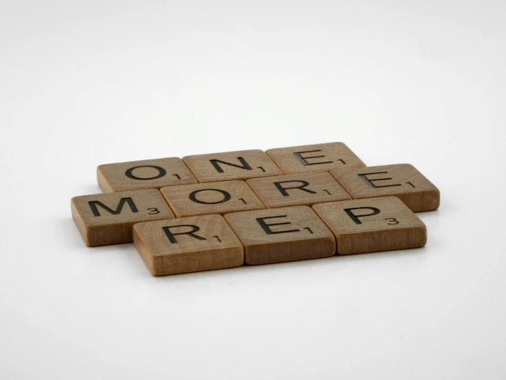 wooden scrabbles spelling one more free on a white background, an album cover, inspired by Ian Hamilton Finlay, temporary art, rap, regrets, on, beige