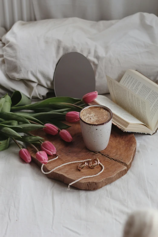 a cup of coffee sitting on top of a wooden tray, by Lucia Peka, pexels contest winner, romanticism, roses and tulips, reading for a party, brown and pink color scheme, full-body