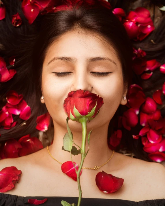 a woman laying down with a rose in her mouth, trending on pexels, flowers growing out of his body, paradise garden massage, red, arabian beauty