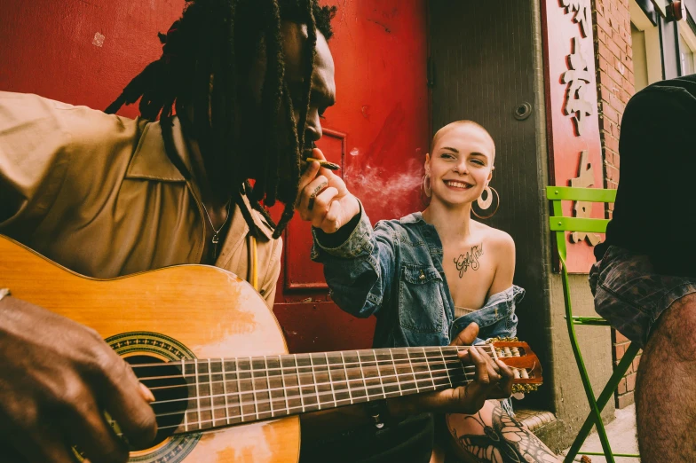 a woman sitting next to a man holding a guitar, pexels contest winner, antipodeans, rastafarian, profile image, in sao paulo, pale-skinned