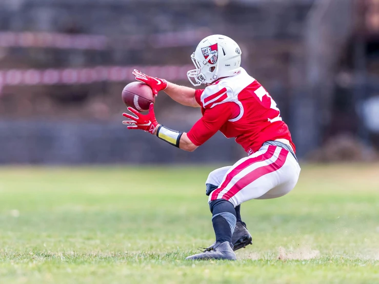 a young man holding a football on top of a field, by Drew Tucker, shutterstock contest winner, white and red armor, in an action pose, sumerville game, red and white