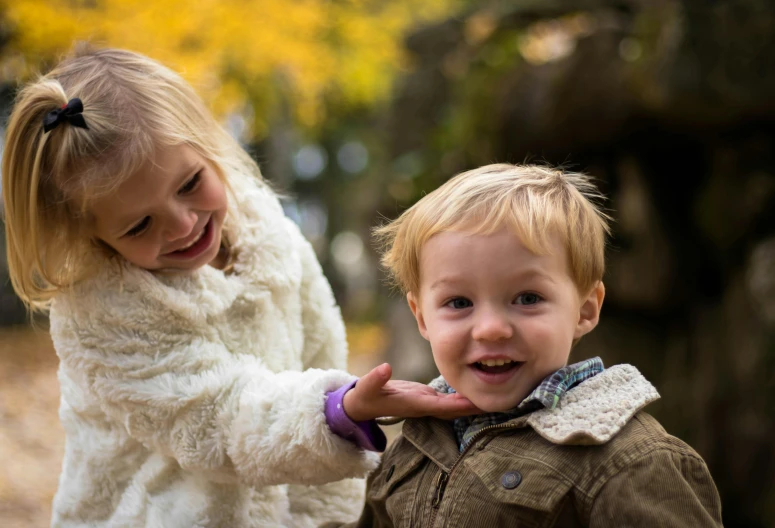 a couple of young children standing next to each other, a picture, pexels contest winner, pleasing, a blond, thumbnail, autum