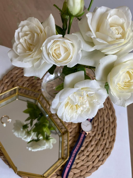 a vase filled with white flowers sitting on top of a table, 👰 🏇 ❌ 🍃, rose crown, in detail, on a reflective gold plate