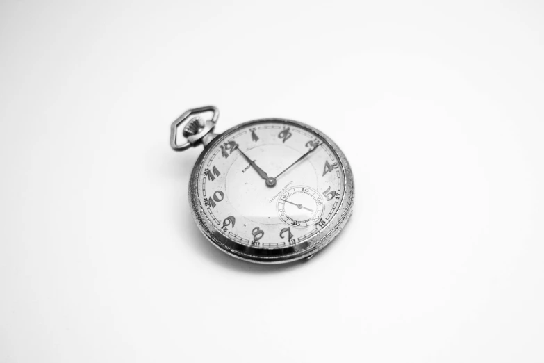 a close up of a pocket watch on a white surface, a black and white photo, bauhaus, uploaded, miscellaneous objects, on white, display item