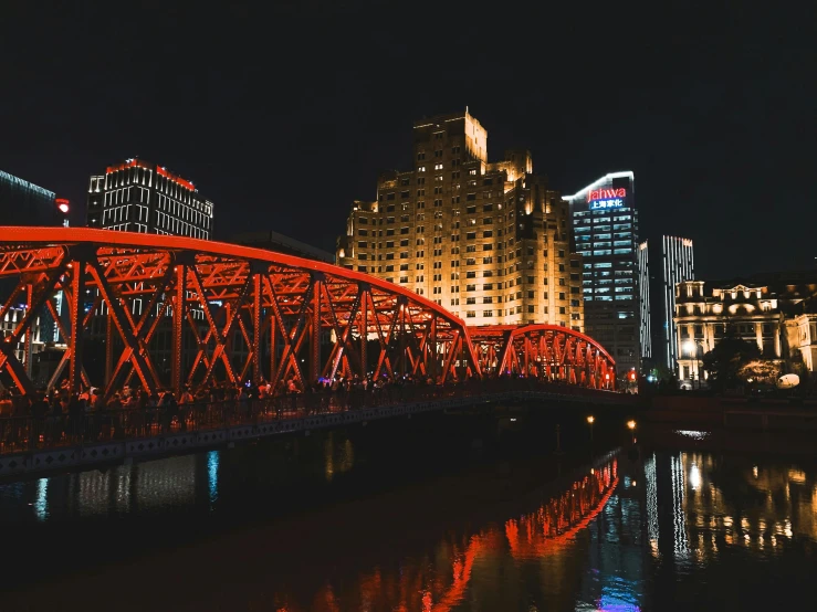 a red bridge over a body of water at night, pexels contest winner, downtown, weibo, black and yellow and red scheme, cleveland